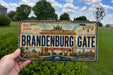 A vintage license plate from Berlin, Germany, with the text "BRANDENBURG GATE" prominently displayed.